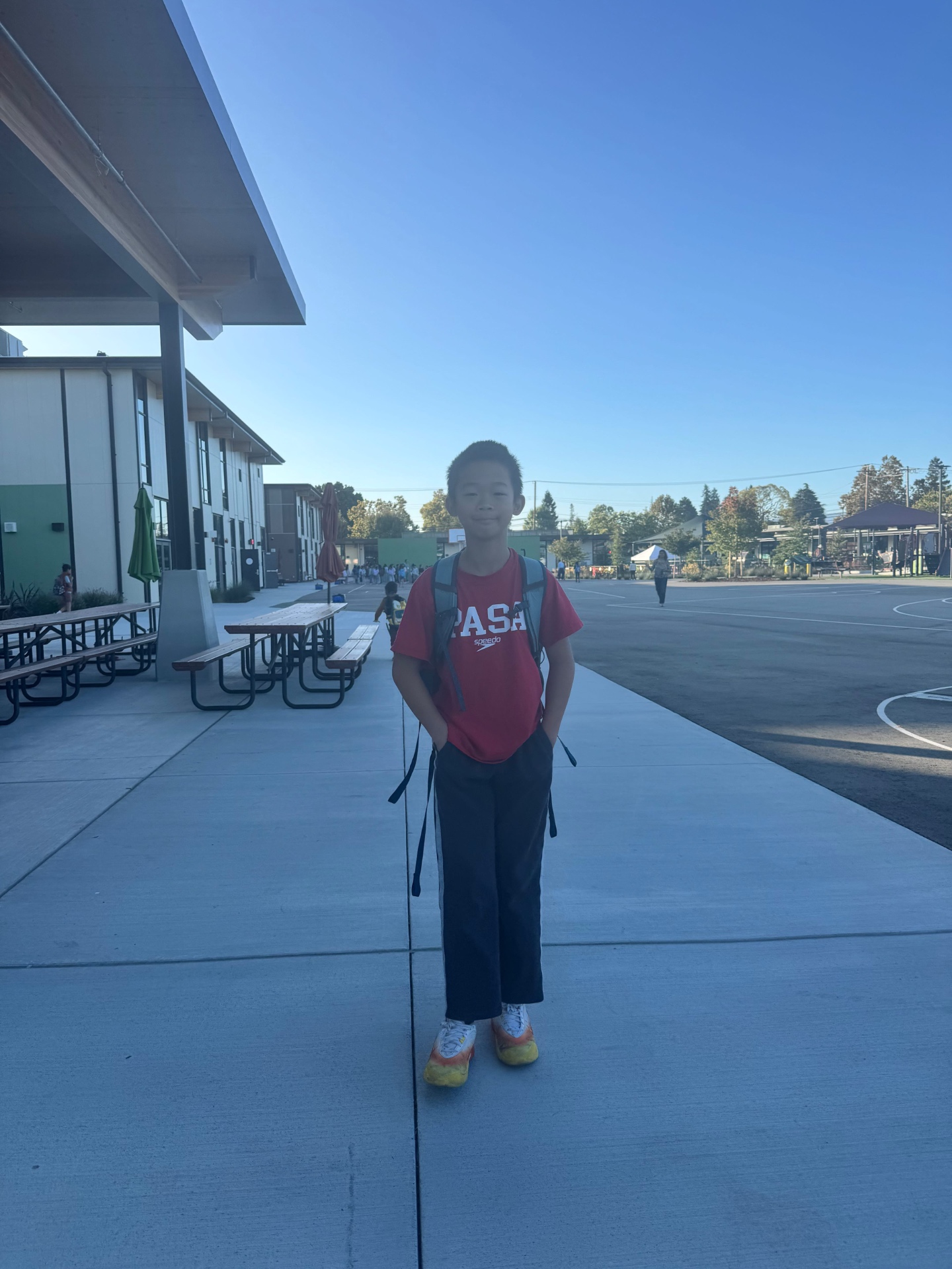 PASA swimmer in team shirt on the school blacktop