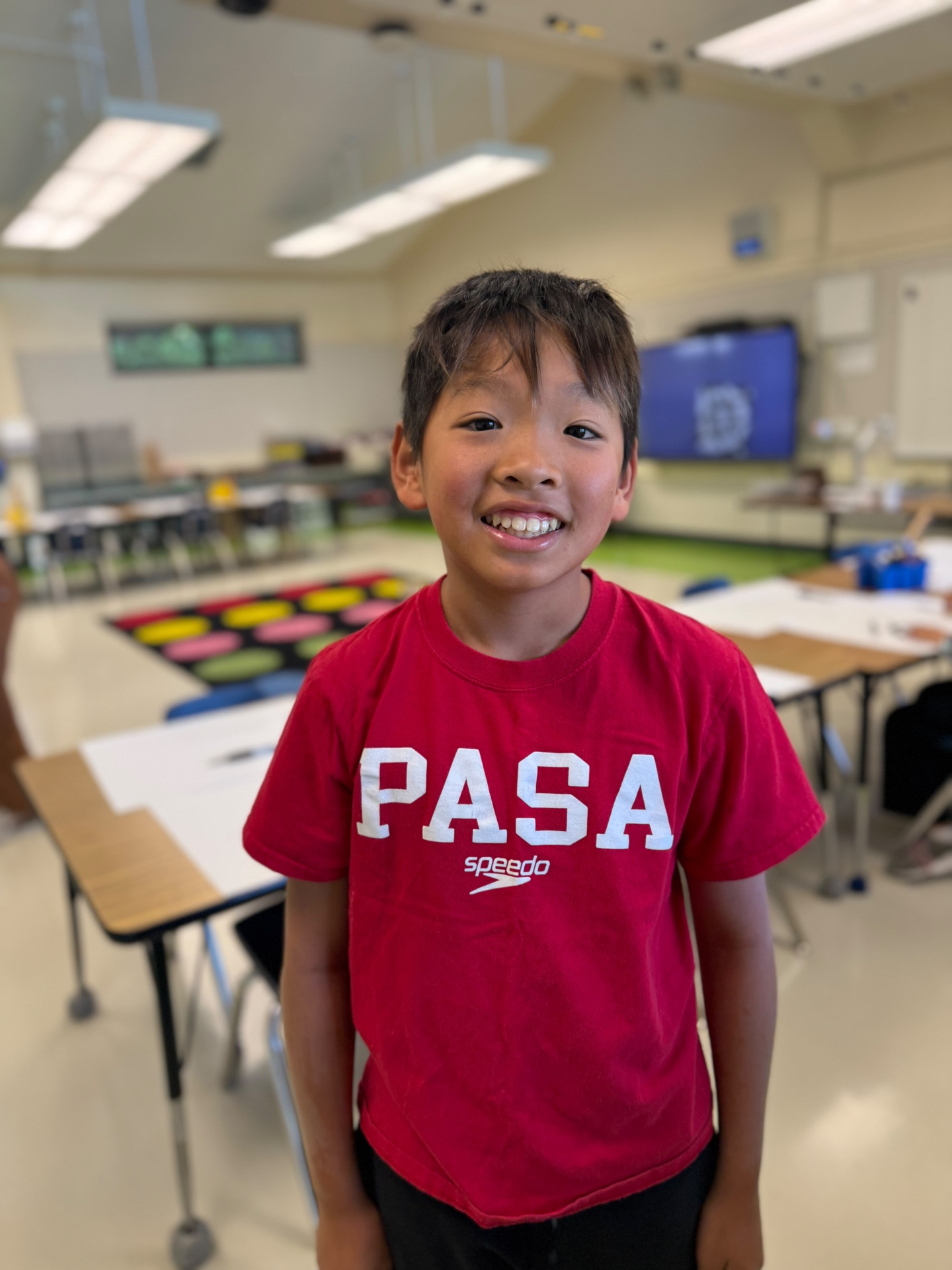 Smiling PASA swimmer in a red team shirt at school