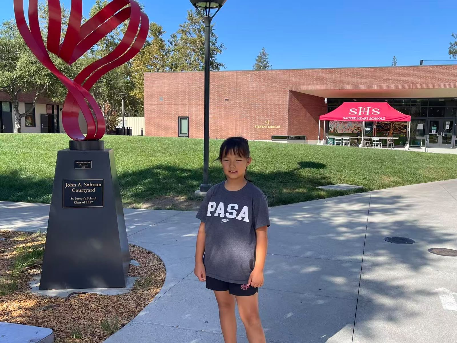 PASA swimmer in team gear at the John A. Sobrato Courtyard