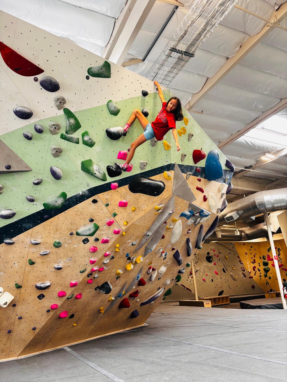 PASA athlete in a red team shirt on the climbing wall